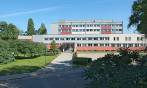 Instytut Niskich Temperatur i Badań Strukturalnych PAN we Wrocławiu. Budynek z czerwonymi i szarymi elementami, otoczony zielenią.
