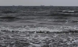 Mroczne morze z falami i statkami na horyzoncie, ukazujące okresowe zmiany poziomu morza.