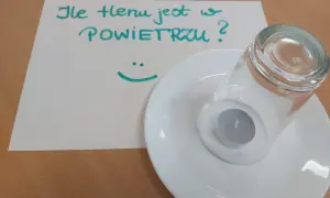 Eksperyment naukowy: ile tlenu jest w powietrzu? Świeczka pod szklanką na talerzyku.