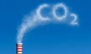 Dym z komina układa się w napis CO2, symbolizując wpływ dwutlenku węgla na człowieka i środowisko.