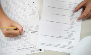 Ręka zaznacza odpowiedzi na arkuszu z biologii rozszerzonej. Zastanawiasz się, ile trwa matura z rozszerzonej biologii?