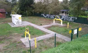 Stacja gazowa z żółtymi rurami i tabliczkami "Uwaga Gaz". Obok biała skrzynka z napisem "Vão:". To miejsce, gdzie sprawdzamy, ch4 co to za gaz.