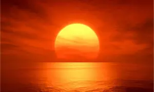 Zachód słońca nad oceanem. Żółta kula Słońca, której temperaturę trudno sobie wyobrazić, odbija się w wodzie.