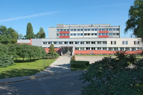 Instytut Niskich Temperatur i Badań Strukturalnych PAN we Wrocławiu. Budynek z czerwonymi i szarymi elementami, otoczony zielenią.