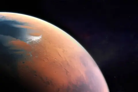Widok Marsa z kosmosu. Czerwona planeta z lodowymi czapami i kraterami. Jaka temperatura jest na Marsie? Niska, średnio -63°C.