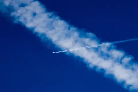 Samolot zostawia smugę na błękitnym niebie. Czy to chemtrails, co to jest?