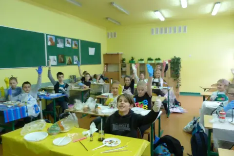 Dzieci w rękawiczkach na lekcji przyrody, podnoszą ręce, gotowe do eksperymentów. Kto może uczyć przyrody? Oni!