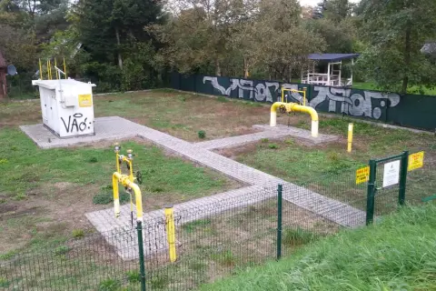 Stacja gazowa z żółtymi rurami i tabliczkami "Uwaga Gaz". Obok biała skrzynka z napisem "Vão:". To miejsce, gdzie sprawdzamy, ch4 co to za gaz.