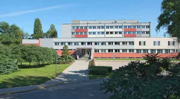 Instytut Niskich Temperatur i Badań Strukturalnych PAN we Wrocławiu. Budynek z czerwonymi i szarymi elementami, otoczony zielenią.
