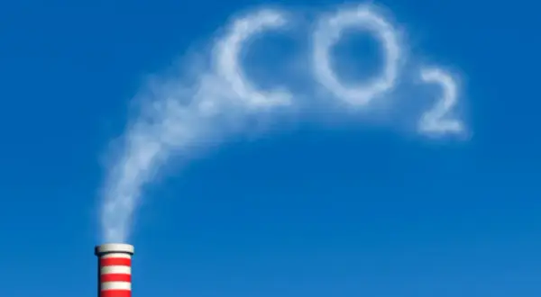 Dym z komina układa się w napis CO2, symbolizując wpływ dwutlenku węgla na człowieka i środowisko.