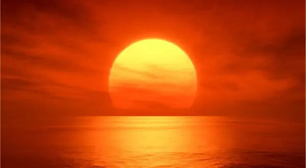 Zachód słońca nad oceanem. Żółta kula Słońca, której temperaturę trudno sobie wyobrazić, odbija się w wodzie.