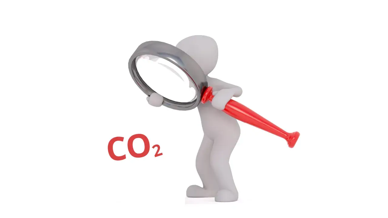 Biała figurka bada pod lupą, czy dwutlenek węgla (CO2) jest szkodliwy.