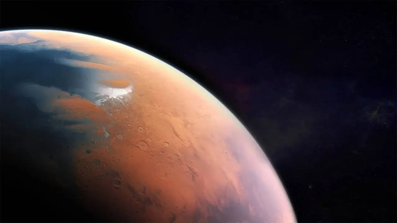 Widok Marsa z kosmosu. Czerwona planeta z lodowymi czapami i kraterami. Jaka temperatura jest na Marsie? Niska, średnio -63°C.