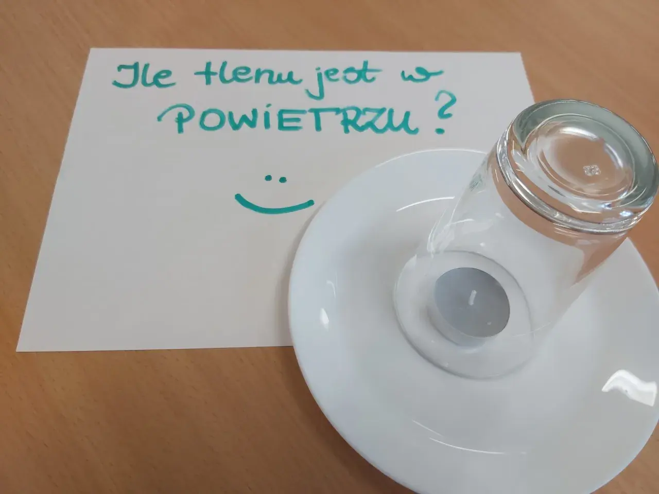 Eksperyment naukowy: ile tlenu jest w powietrzu? Świeczka pod szklanką na talerzyku.