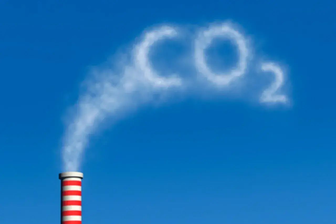Dym z komina układa się w napis CO2, symbolizując wpływ dwutlenku węgla na człowieka i środowisko.