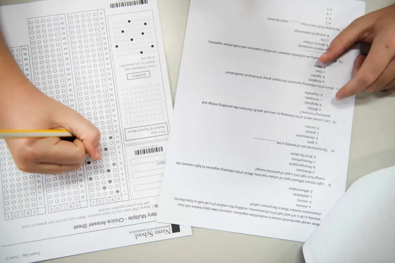 Ręka zaznacza odpowiedzi na arkuszu z biologii rozszerzonej. Zastanawiasz się, ile trwa matura z rozszerzonej biologii?