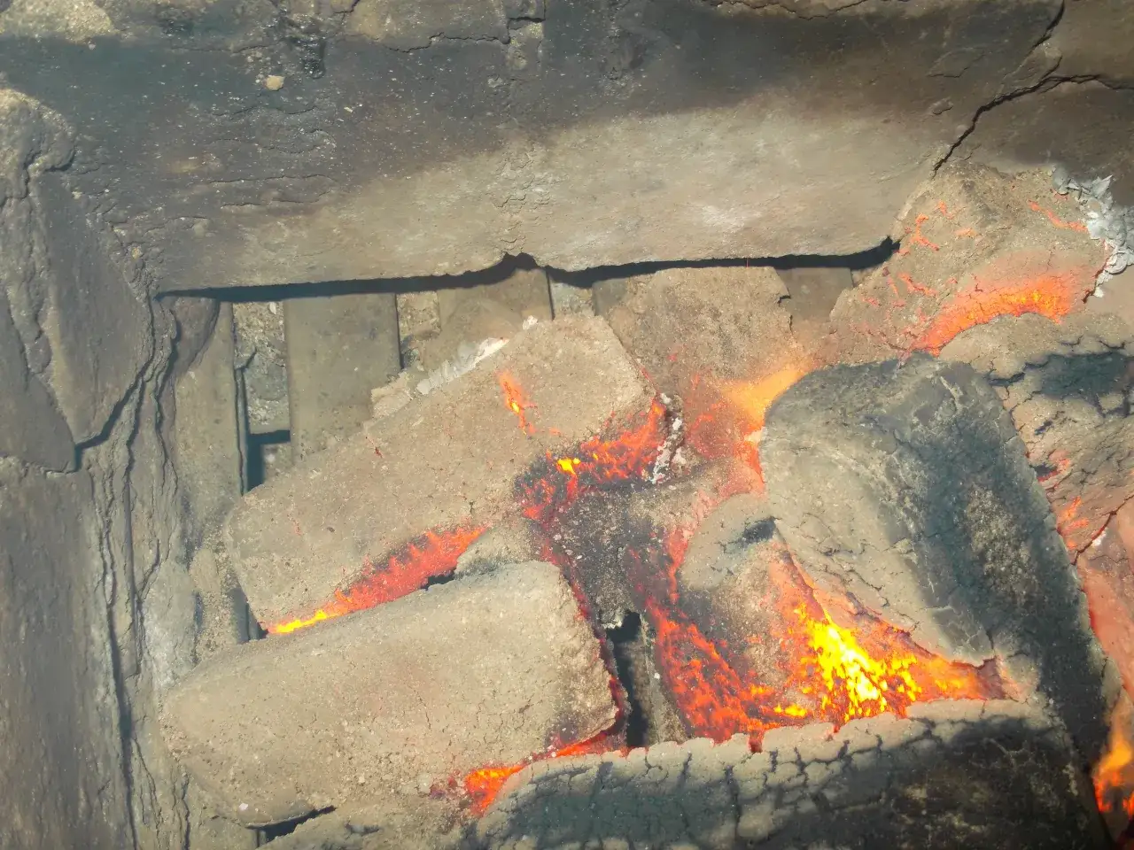 Żarzące się węgle w piecu. Spalanie węgla emituje CO2, a dokładne obliczenie, ile CO2 z tony węgla, zależy od jego składu.