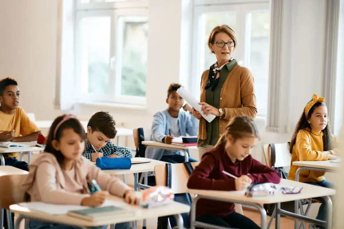 Nauczycielka geografii z pasją tłumaczy uczniom tajniki przyrody. Dzieci pilnie notują, a sala lekcyjna tętni życiem.