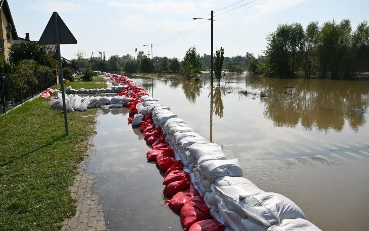 Zapora z worków z piaskiem chroni domy przed wodą. To obraz jednej z przyczyn powodzi w Polsce – gwałtowne wezbranie rzek.