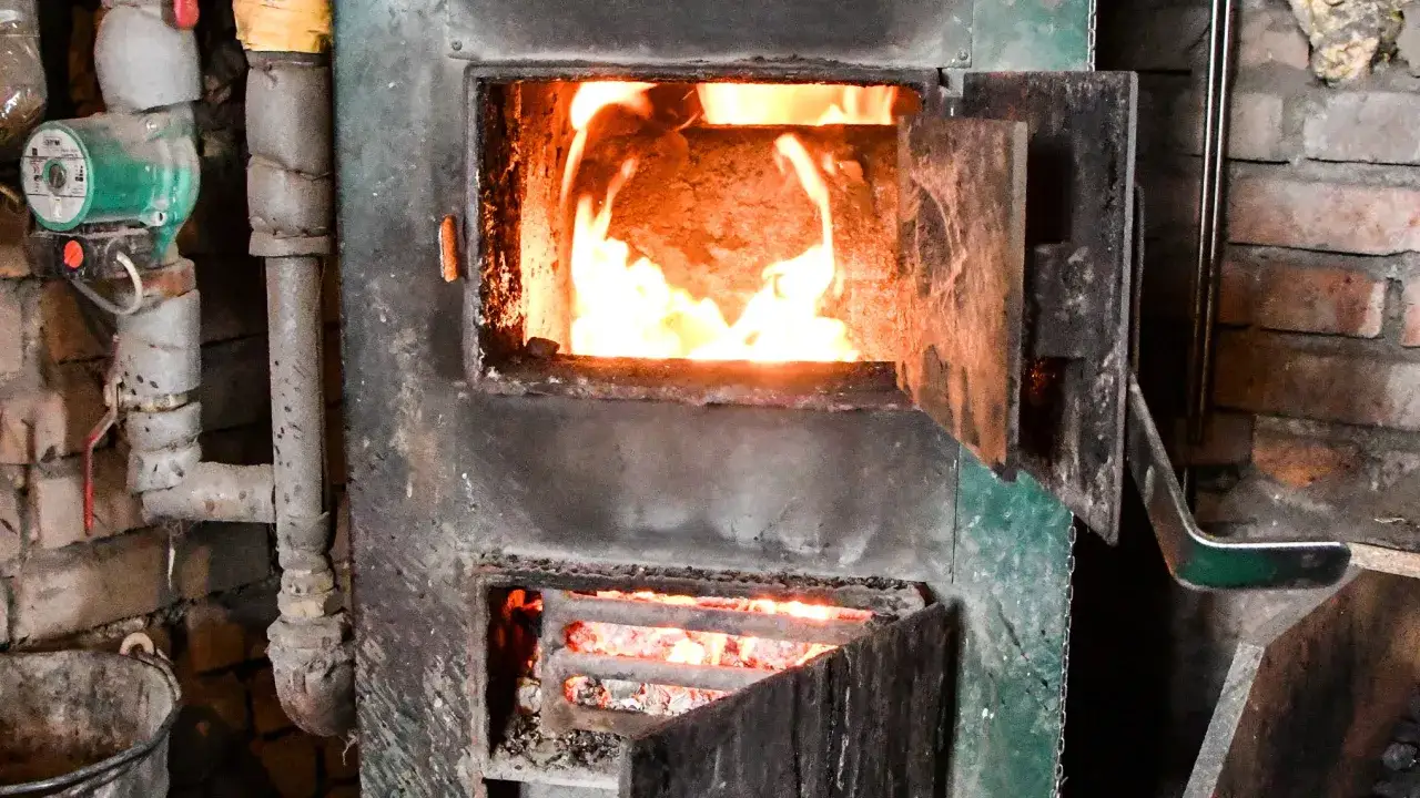 Piec węglowy z płomieniami. Spalanie węgla generuje CO2, zastanawiasz się, ile CO2 z tony węgla?